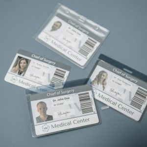 High-angle view of medical ID badges for chief surgeons on a gray surface.