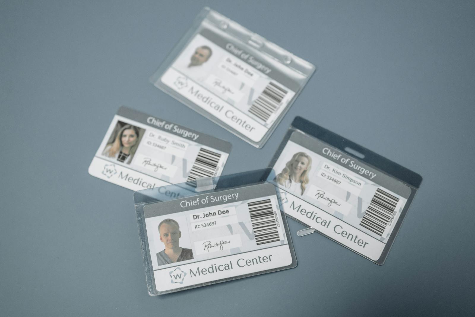 High-angle view of medical ID badges for chief surgeons on a gray surface.